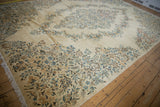 Dense clusters of sky blue, apricot, and cream blossoms on an ivory Kerman carpet field.