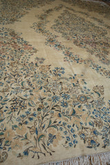 Dense clusters of sky blue and apricot blossoms on ivory vintage Kerman carpet with fringe.
