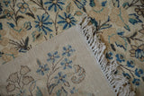 Vintage Kerman carpet's tightly woven foundation, knotted fringe, and blue floral details.