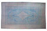 Distressed Persian Meshed carpet with pale sky blue field, floral medallion, and unique geometric border.