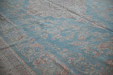 Distressed vintage Meshed rug detail: floral bouquets, pale sky blue, geometric arabesque border.