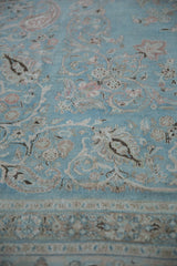 Vintage Meshed rug's pale blue geometric border, worn floral design, and heavy abrashes.