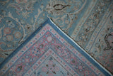 Distressed vintage Meshed carpet corner, displaying pale blue field and dusty rose arabesque border.