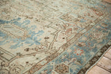 Distressed corner of a vintage Mehrivan carpet with pale blue border, geometric blossoms.