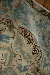 Vintage distressed Mehrivan carpet pile showing pale denim blue, ivory, and geometric dark border.