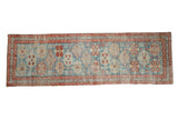 Antique Northwest Persian runner rug with a distressed geometric pattern of medallions in powder blue, cherry red, and ivory.