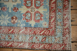 Corner close-up of an antique Persian runner with its reciprocating wave border in cherry red.
