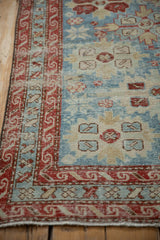 Cherry red border featuring a reciprocating wave design against the distressed powder blue field.