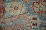 Corner of an antique Persian rug folded to reveal the detailed hand-knotted foundation and weave.