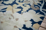 Tibetan carpet detail: sprawling saffron and beige floral palmettes on a cobalt blue ground.