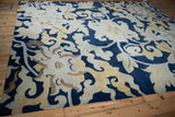 Curvilinear saffron and beige floral palmettes with vines on a cobalt blue Tibetan rug.