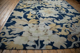 Curvilinear floral palmettes and leaves in beige, saffron yellow on cobalt blue Tibetan rug.