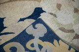 Folded vintage Tibetan carpet showcasing thick pile and macro floral design in cobalt blue, beige.