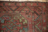 Distressed antique Ersari rug border detail with dusty raspberry, jade, and sky blue hues.