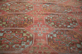 Distressed antique Ersari carpet featuring faded raspberry guls, dusty blue, and worn pile.