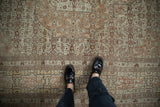 Overhead view of the antique Tabriz carpet's cartouche border and Herati field pattern.