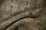 Folded view of an antique Tabriz carpet highlighting the dense pile and warm, time-softened patina.