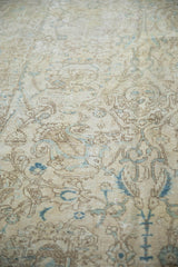 Distressed vintage Tabriz carpet texture with faded ivory, beige, and powder blue curvilinear floral motifs.