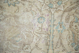 Distressed vintage Tabriz carpet texture with ivory field, faded sky blue and dusty mauve scrolling floral motifs.