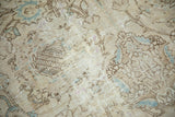 Close-up of distressed Tabriz carpet pile, tone-on-tone scrolling floral design in beige, blue, and mauve.