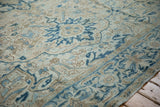 Evenly worn pile on a vintage Heriz rug showing leaf motifs in cobalt blue, sand, and cream.