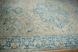 Angled shot of a vintage Heriz showing the even wear across its blue and cream floral pattern.