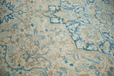 Close view of the sprawling leaf and blossom design on the low, evenly worn pile of a Heriz carpet.