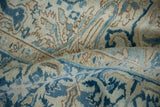 The soft, low-pile texture of a vintage Heriz rug in blue, sand, and cream tones.