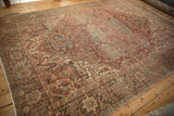 Distressed Heriz carpet: arabesque field, floral border, dusty red and muted silver tones.