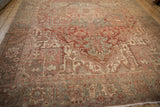 Distressed Heriz border pattern in dusty red, oxidized silver, beige, with visible fringe.