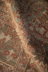 Distressed vintage Heriz carpet pile with muted raspberry, silver, and beige geometric motifs, showing even wear.