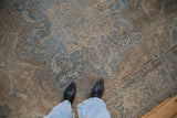 Textured Indian Ahar carpet with Souf weave, showing distressed blue floral patterns on a beige field.