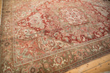 Distressed Heriz rug corner, showing Herati and Turtle Samovar border, with faded red and olive tones.