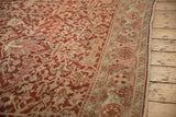 Distressed burgundy field of a vintage Heriz carpet with intricate vinery and faded Herati border.