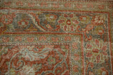 Distressed Mahal rug close-up: terracotta, green, charcoal floral arabesques with visible knot heads.