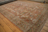Distressed Mahal carpet corner, with muted terracotta, green, and ivory floral arabesque border.