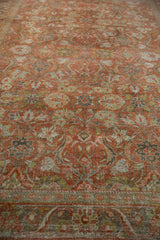Textural details of the vintage Mahal carpet's distressed terracotta field and curvilinear design.