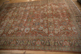 Distressed Persian Mahal carpet detail with terracotta scrolling arabesques and worn texture.
