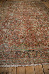 Distressed terracotta and green floral motifs with cream fringe on a vintage Mahal carpet.