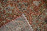 Distressed Mahal pile in terracotta, rust, blue; visible foundation with weavers' meeting place.