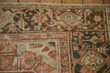 Heriz carpet corner detail showing geometric leaves in terracotta, charcoal, and oxidized silver tones.