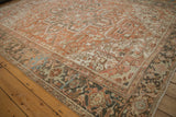 Vintage Heriz carpet: terracotta field, geometric blossoms, charcoal border, with heavy abrashes.