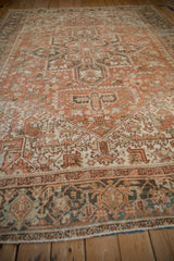 Hand-knotted Heriz rug end displaying geometric border in charcoal, terracotta, and pale blue.