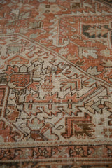 Detail of vintage Heriz carpet showing geometric blossoms, sharp serrated leaves, time-softened tones.