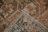 Vintage Heriz carpet: Wrapped selvage and hand-knotted texture with terracotta, charcoal, blue patterns.