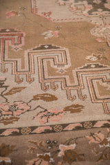 Distressed Kars carpet detail showing coffee brown geometric hooks and dusty mauve florals.