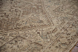 Textured, distressed geometric Heriz patterns with visible wear in earthy browns and subtle blue.