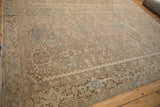 Distressed vintage Heriz carpet displaying Karaja stylized geometric panels in pale brown and blue.