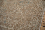 Distressed vintage Heriz carpet's Karaja stylized geometric panels with soft brown and blue.