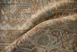Folded distressed vintage Heriz rug, with Karaja stylized panels in pale brown and blue.